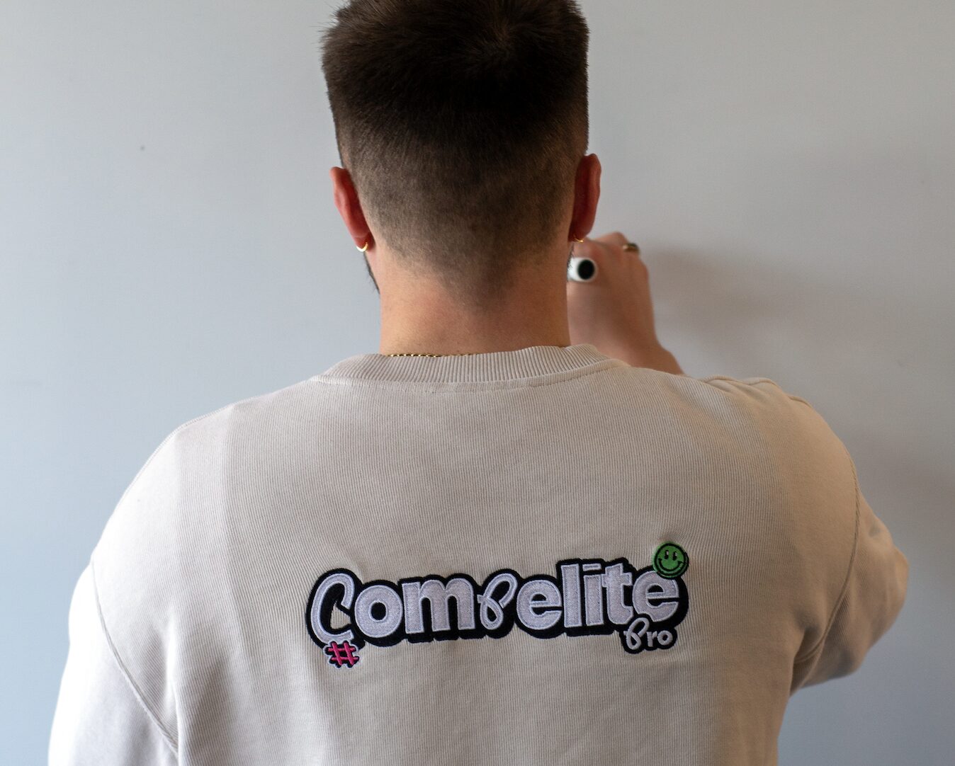 Compelite Pro team member wearing branded sweatshirt while reviewing content on the studio wall