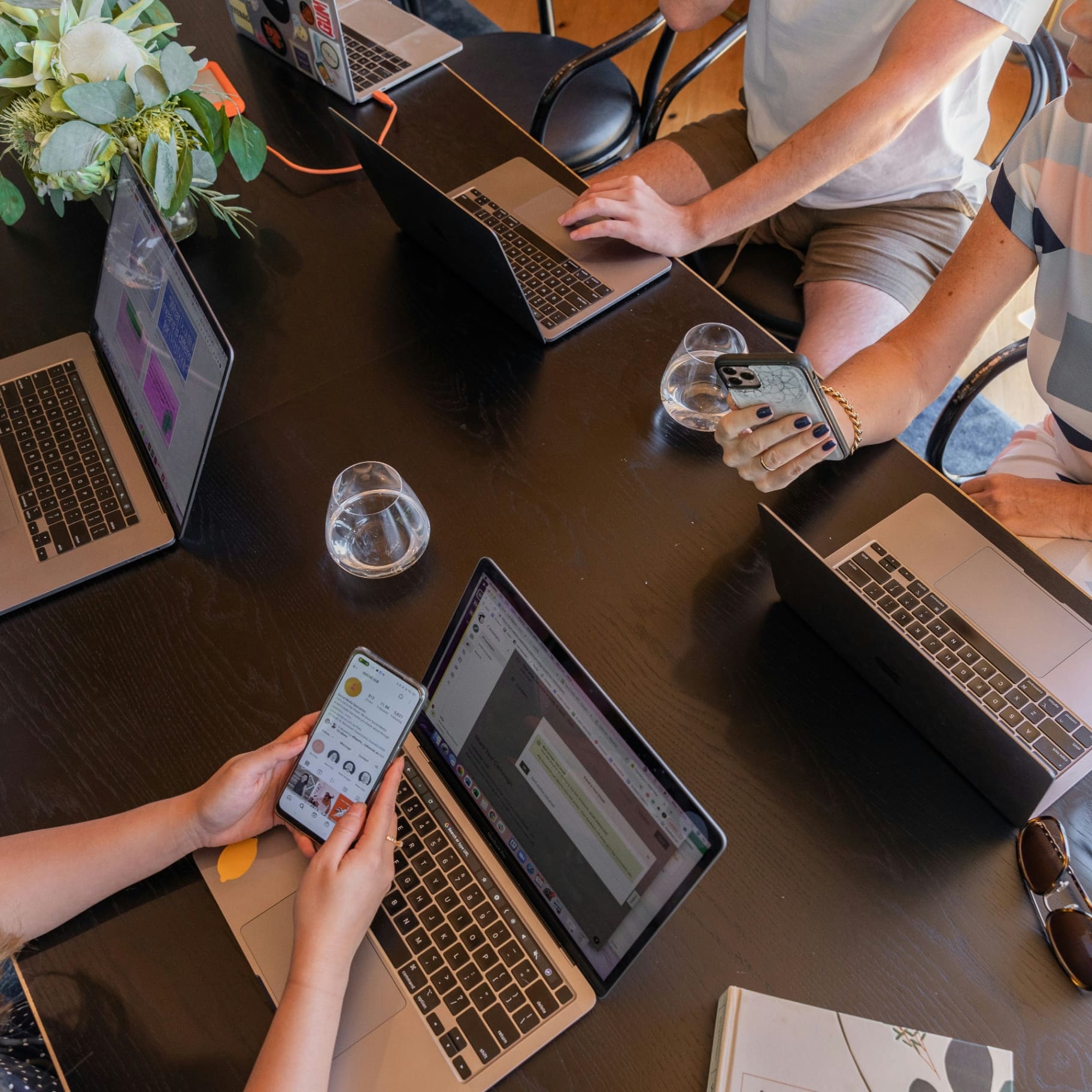 Compelite Pro team creating social media content on laptops and phones