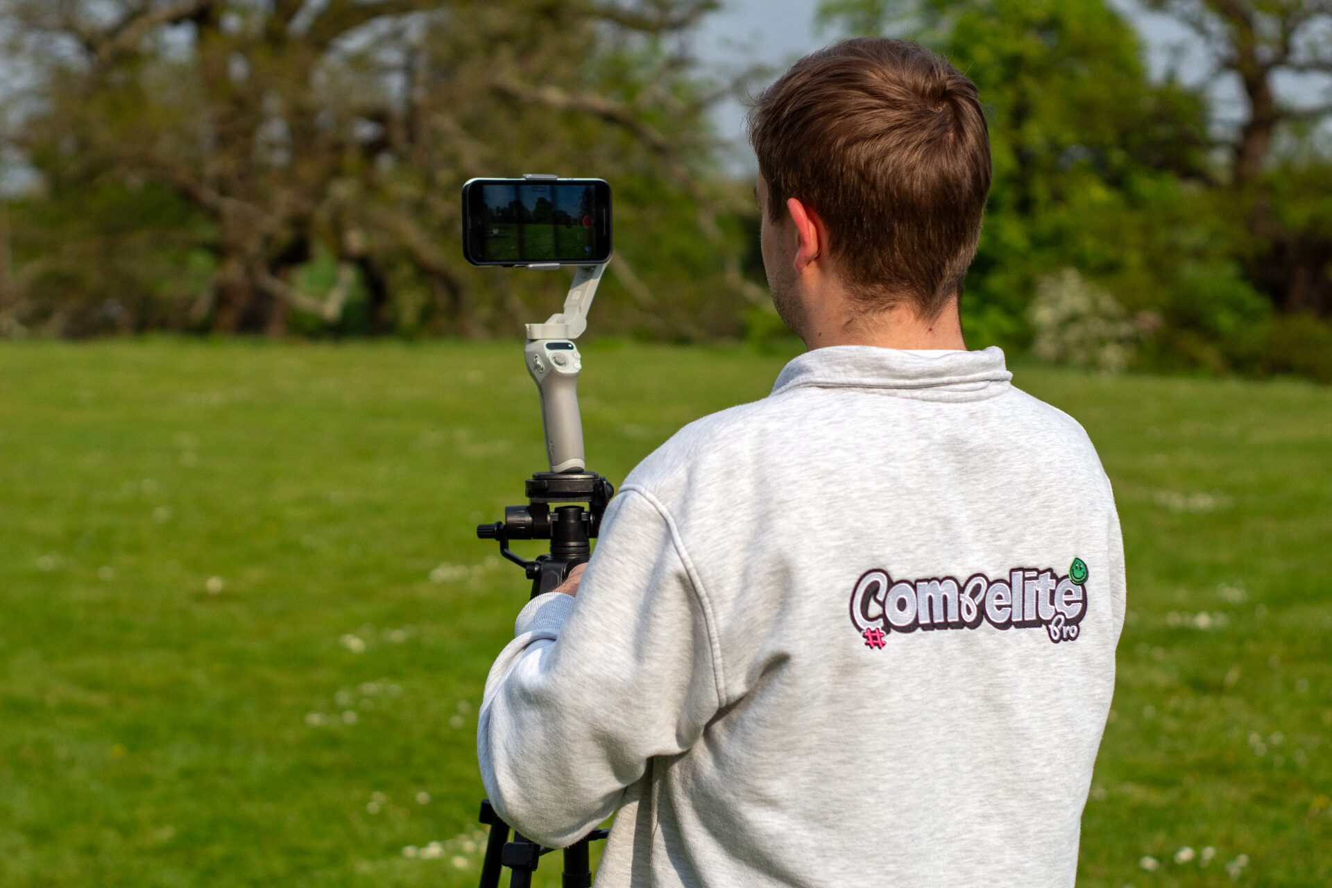 Compelite Pro team member filming outdoor content with a phone gimbal on a tripod