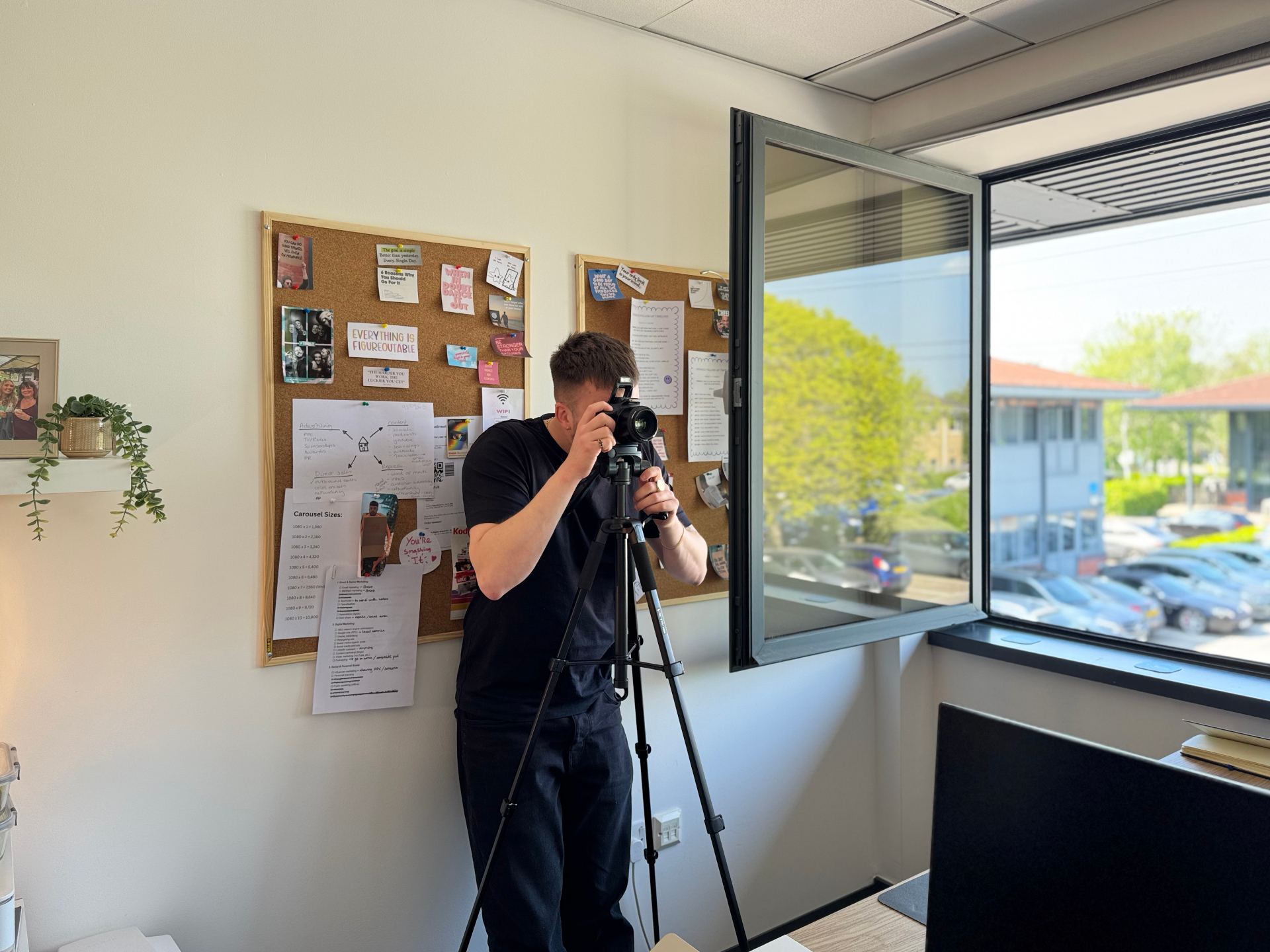 Compelite Pro photographer setting up a tripod-mounted camera in the Bristol studio in front of a strategy moodboard