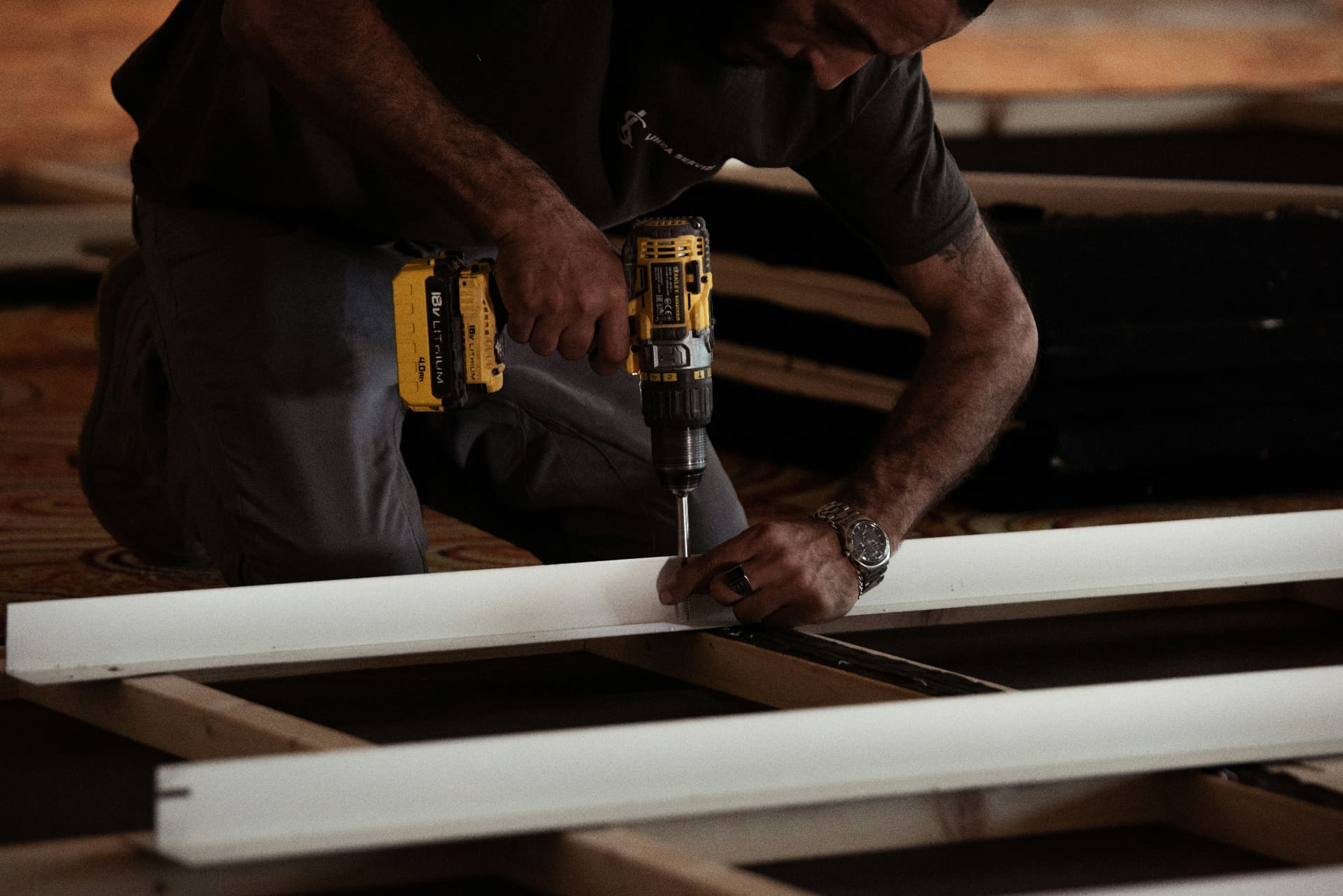 Tradesperson using a cordless drill to assemble a door frame on site — social media agency for trades and construction businesses