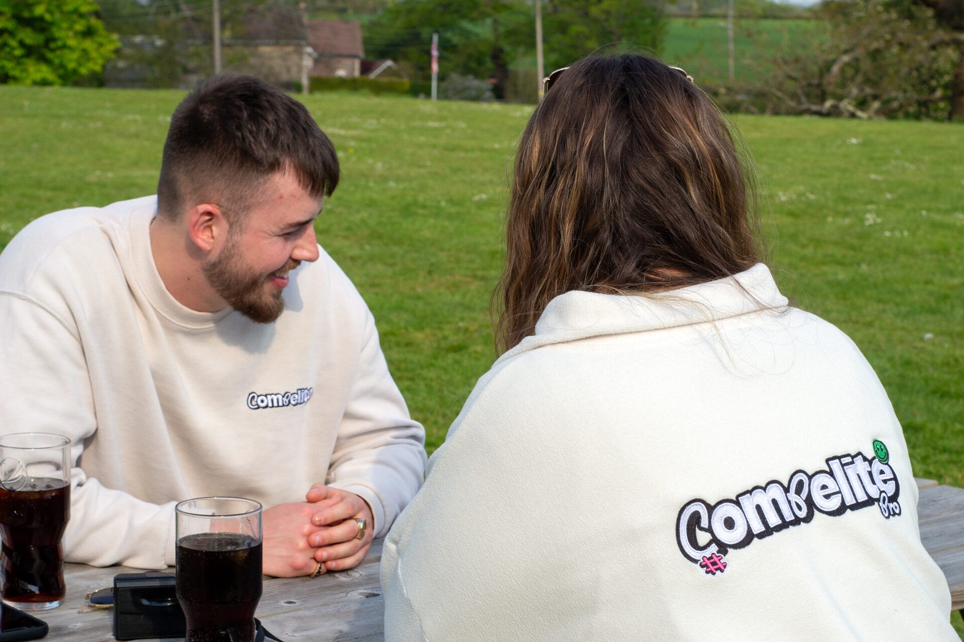 Compelite Pro team members in branded sweaters meeting outdoors