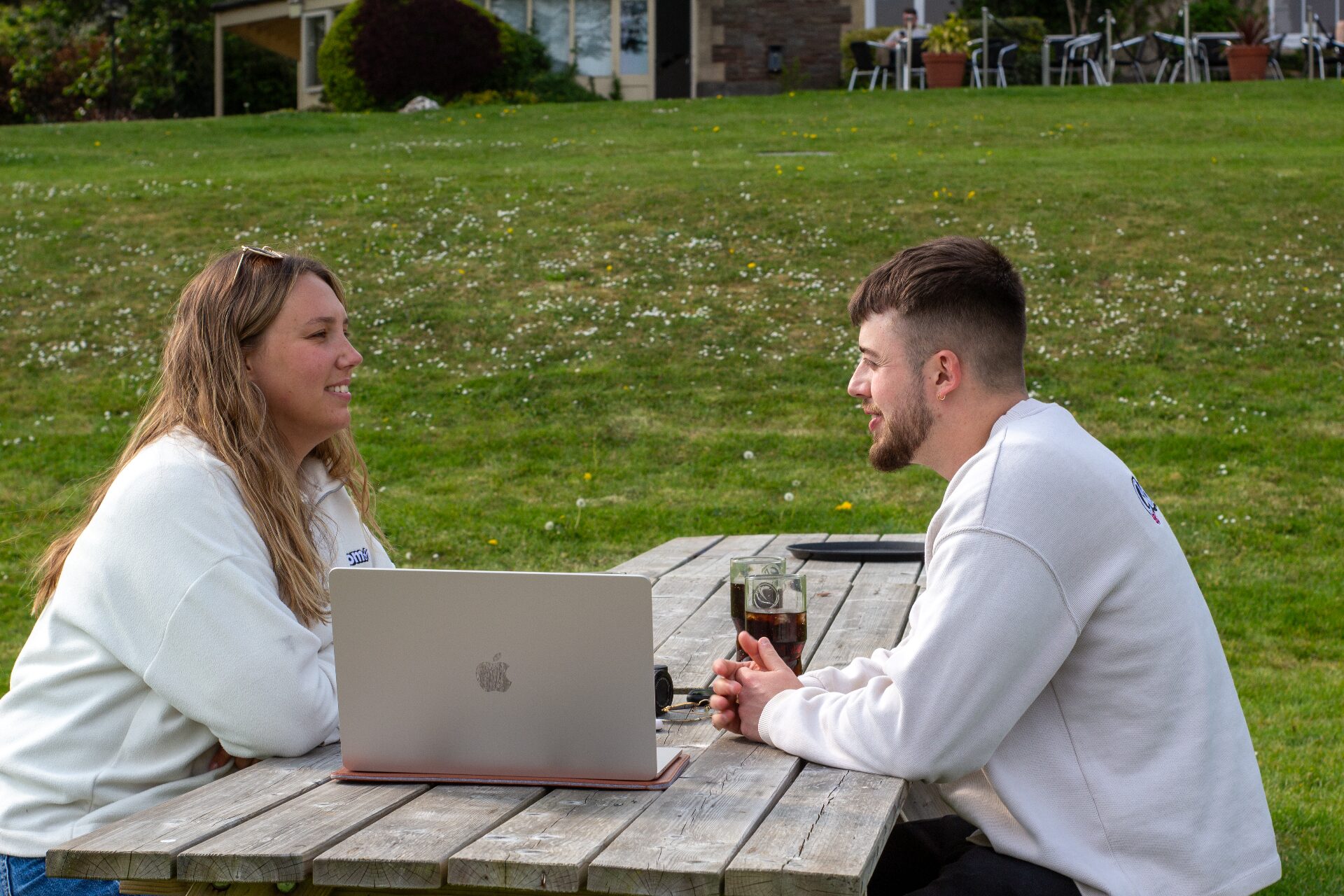 Compelite Pro team meeting outdoors over a laptop in Bristol — strategy session in the sunshine